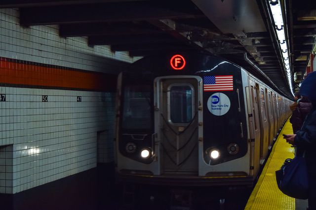 An F train in the station at 47-50th subway station.